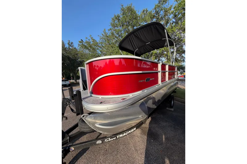 The Image of 2026 Sun Tracker Party Barge 18 DLX pontoon boat with red exterior and canopy. - 0