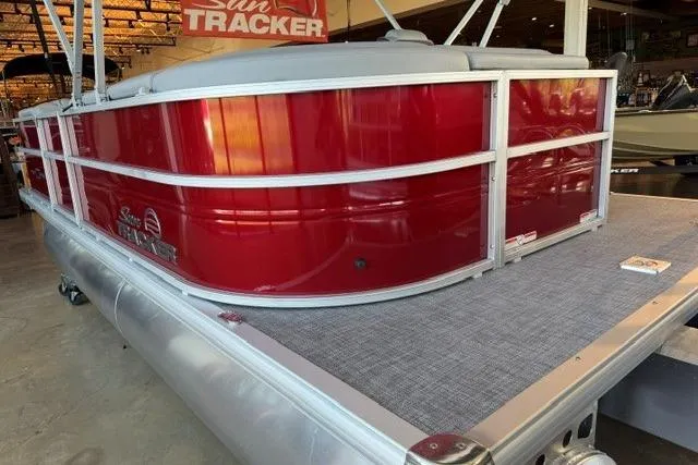 Slide: The Image of 2026 Sun Tracker Party Barge 20 DLX pontoon boat with red exterior in showroom. - 4