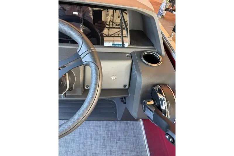 Slide: The Image of Steering console of 2026 Sun Tracker Party Barge 20 DLX with cup holder and throttle. - 14