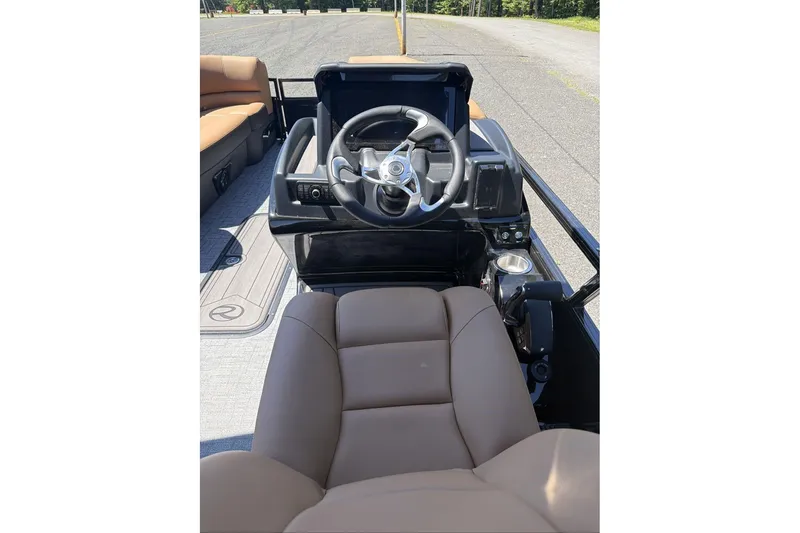 Slide: The Image of 2026 Regency 230 DL boat interior with steering wheel and brown seating. - 10