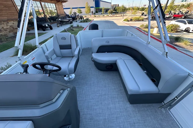 Slide: The Image of 2026 Sun Tracker Party Barge 18 DLX interior with gray seating and steering console. - 29