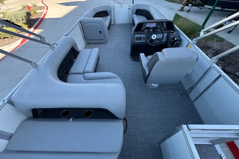 Slide: The Image of 2026 Sun Tracker Party Barge 18 DLX interior with gray seating and steering console. - 31