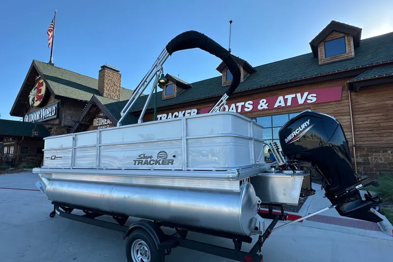 The Image of 2026 Sun Tracker Party Barge 18 DLX pontoon boat displayed outside a store. - 14
