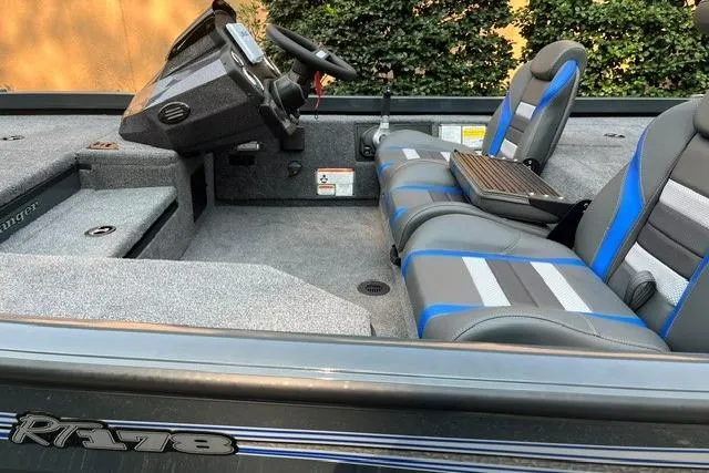 Slide: The Image of 2026 Ranger RT178 boat interior with gray and blue seating, steering console, and carpeted flooring. - 8