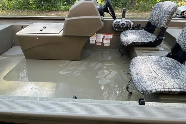 Slide: The Image of 2026 Tracker Grizzly 1754 SC boat interior with camouflage seats and steering console. - 4