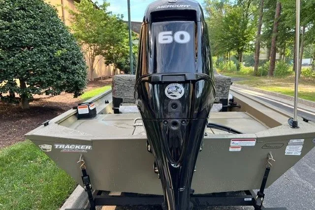 Slide: The Image of 2026 Tracker Grizzly 1754 SC boat with Mercury 60 engine, parked outdoors. - 2