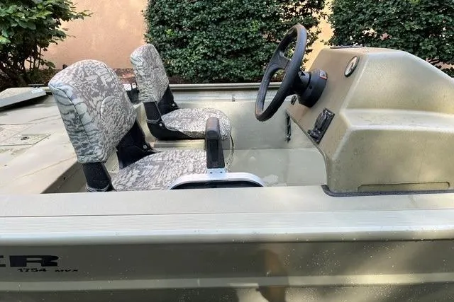 Slide: The Image of 2026 Tracker Grizzly 1754 SC boat interior with camo seats and steering console. - 5