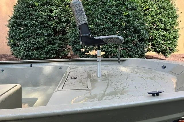 Slide: The Image of 2026 Tracker Grizzly 1754 SC boat with camo seat, set against lush greenery. - 6