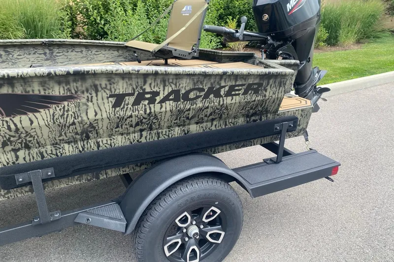 Slide: The Image of 2026 Tracker Grizzly 1650 T Prairie Wings Edition boat on trailer, camo design, Mercury engine. - 31