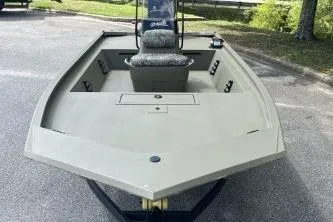 Slide: The Image of 2026 Tracker Grizzly 1860 CC boat, parked on pavement, showcasing spacious deck and seating. - 6