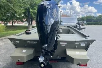 Slide: The Image of 2026 Tracker Grizzly 1860 CC boat with outboard motor, parked outdoors. - 5