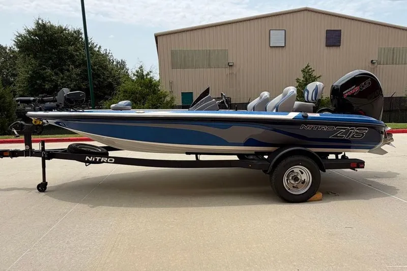 Slide: The Image of 2026 Nitro Z18 Pro fishing boat on trailer, blue and gray design, parked outdoors. - 4
