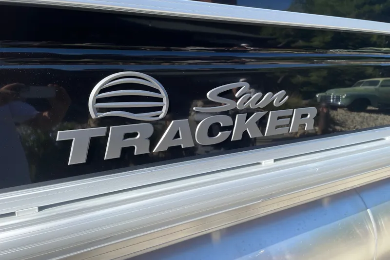 Slide: The Image of 2026 Sun Tracker SportFish 20 DLX logo on a sleek black surface. - 24