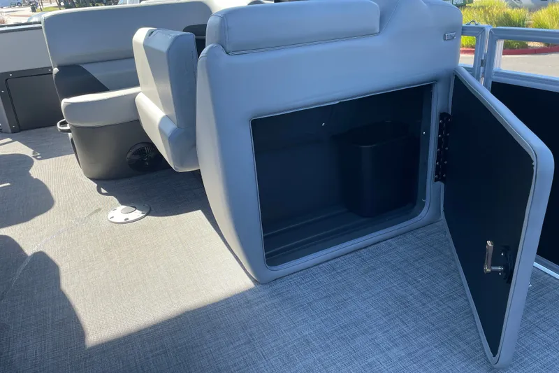 Slide: The Image of 2026 Sun Tracker SportFish 20 DLX interior storage compartment with open door. - 15