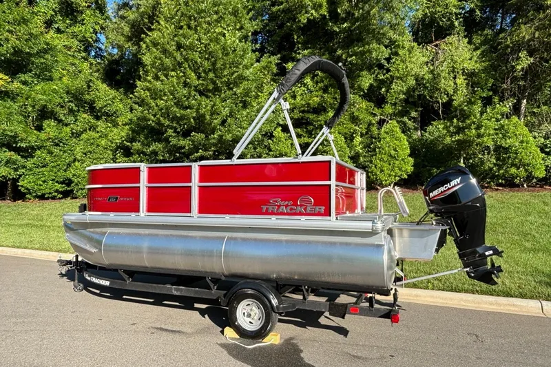 Slide: The Image of 2026 Sun Tracker Party Barge 16 DLX pontoon boat on trailer, parked outdoors. - 3