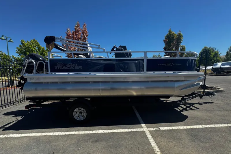 The Image of 2026 Sun Tracker Bass Buggy 18 DLX pontoon boat parked in a sunny lot. - 0
