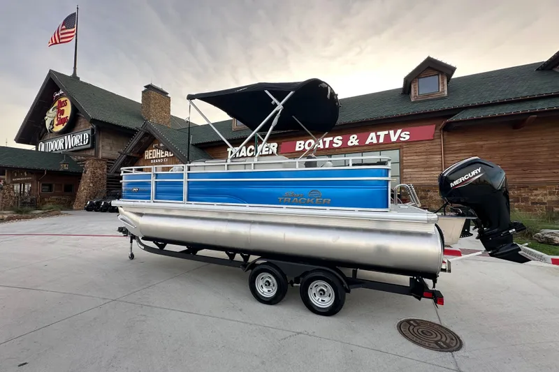 The Image of 2026 Sun Tracker Fishin' Barge 20 DLX pontoon boat displayed outside a store. - 35