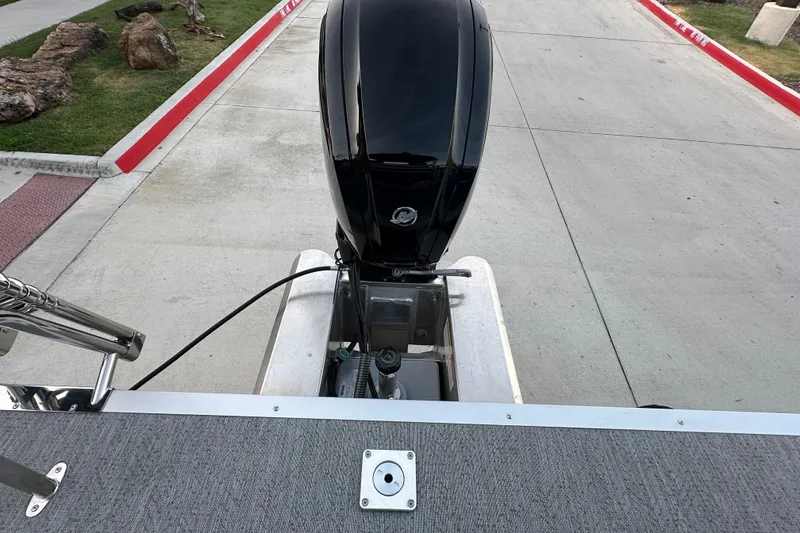 Slide: The Image of 2026 Sun Tracker Fishin' Barge 20 DLX with outboard motor, parked on concrete. - 54