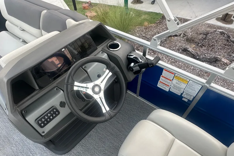 Slide: The Image of 2026 Sun Tracker Fishin' Barge 20 DLX helm with steering wheel and controls. - 57
