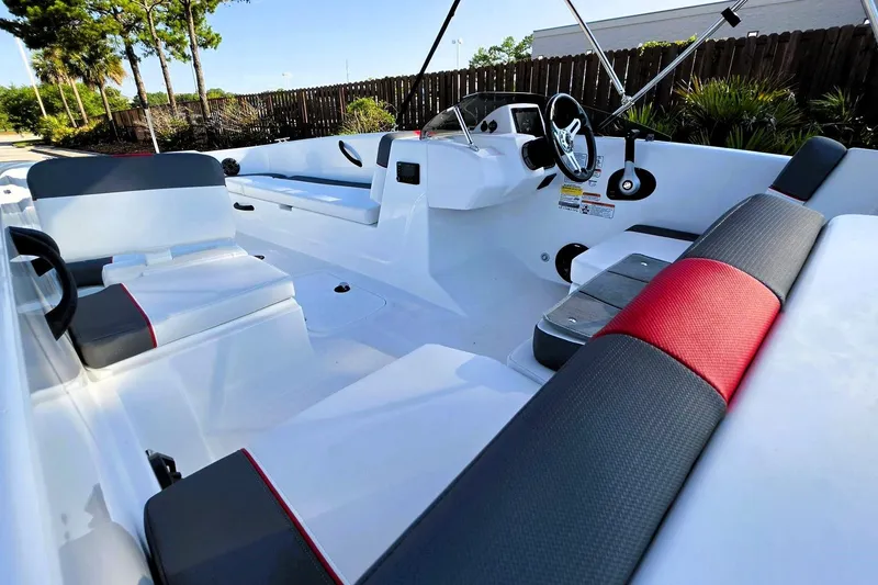 Slide: The Image of 2026 Tahoe T18 boat interior with modern seating and steering wheel, surrounded by lush greenery. - 15