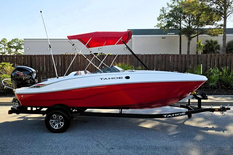 The Image of 2026 Tahoe T18 boat with red hull and canopy on a trailer. - 0
