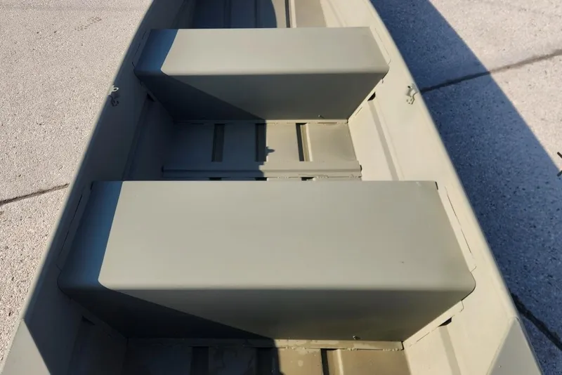 Slide: The Image of 2026 Tracker Grizzly 12 Jon boat interior with bench seats, shown on pavement. - 31