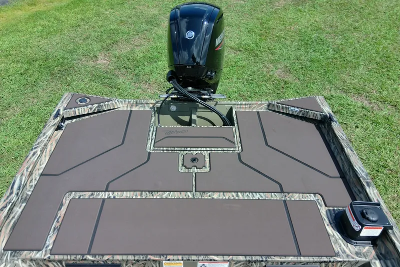 Slide: The Image of 2026 Tracker Grizzly 1860 CC boat deck with camo design and Mercury outboard motor. - 22