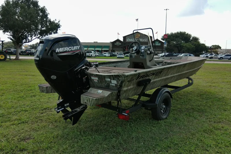 Slide: The Image of 2026 Tracker Grizzly 1860 CC boat with Mercury engine on grassy field. - 13
