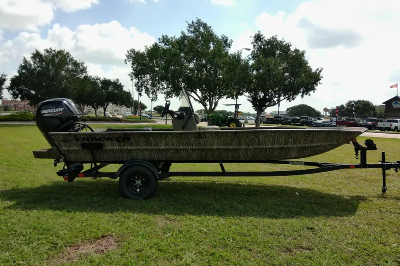 Slide: The Image of 2026 Tracker Grizzly 1860 CC boat on trailer, parked on grass under cloudy sky. - 14