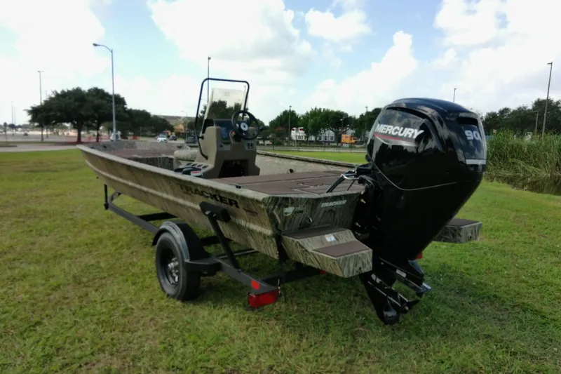 Slide: The Image of 2026 Tracker Grizzly 1860 CC boat with Mercury 90 engine on grassy area. - 11