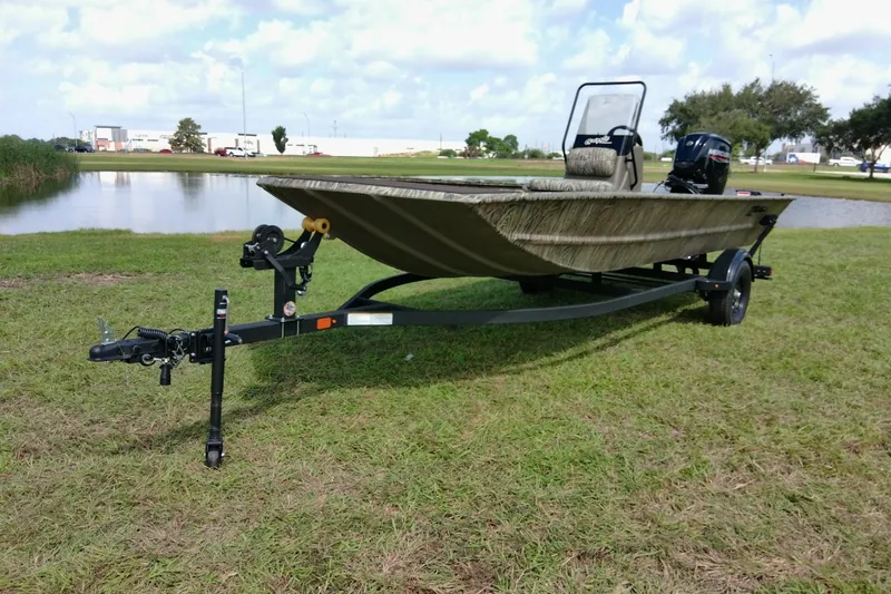Slide: The Image of 2026 Tracker Grizzly 1860 CC boat on trailer by a pond, grassy area. - 9