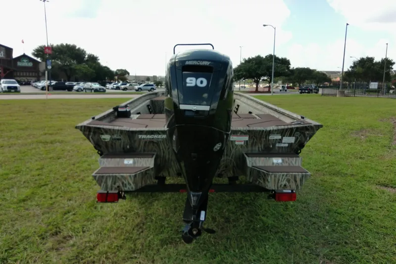 Slide: The Image of 2026 Tracker Grizzly 1860 CC boat with Mercury 90 engine on grassy field. - 12