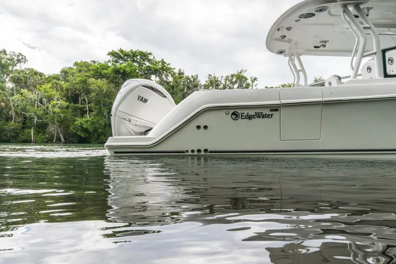 Slide: The Image of Edgewater 2026 boat with Yamaha engine on calm water, surrounded by lush greenery. - 1