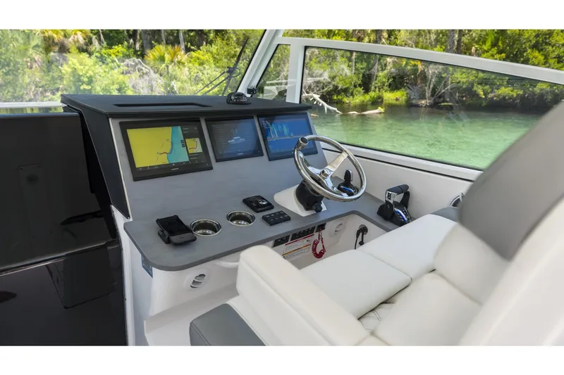 Slide: The Image of Helm of 2026 Edgewater boat with advanced navigation displays and steering wheel. - 12