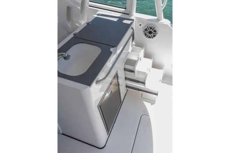 Slide: The Image of 2026 Edgewater boat interior with sink, storage drawers, and speaker, overlooking water. - 15