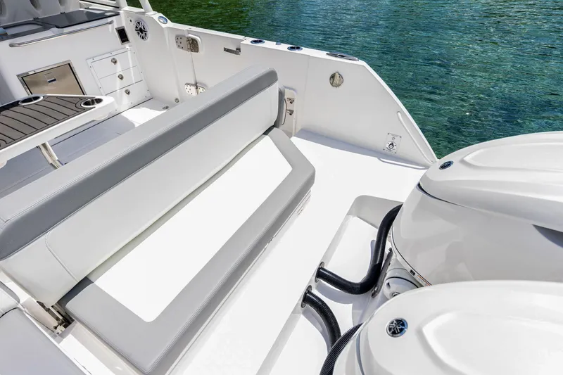 Slide: The Image of 2026 Edgewater boat interior with seating, storage, and dual outboard motors on clear water. - 18