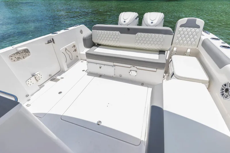 Slide: The Image of 2026 Edgewater boat interior with cushioned seating and storage, set against a serene water backdrop. - 21