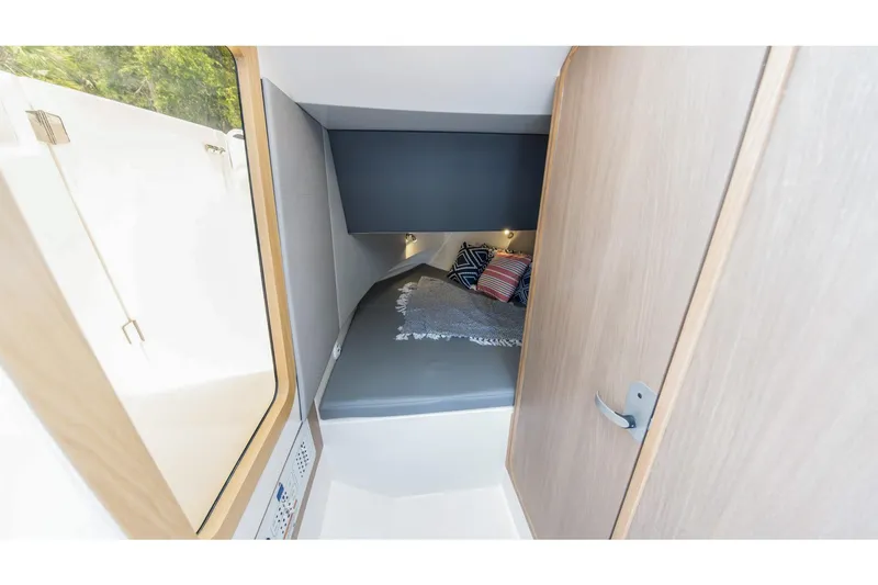 Slide: The Image of Compact cabin interior of 2026 Edgewater boat with cozy bed and decorative pillows. - 25