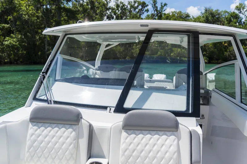 Slide: The Image of 2026 Edgewater boat with sleek design, featuring comfortable seating and clear windshield on a sunny day. - 5