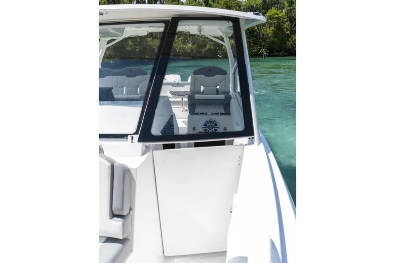 Slide: The Image of 2026 Edgewater boat interior with seating, glass enclosure, and scenic water view. - 6