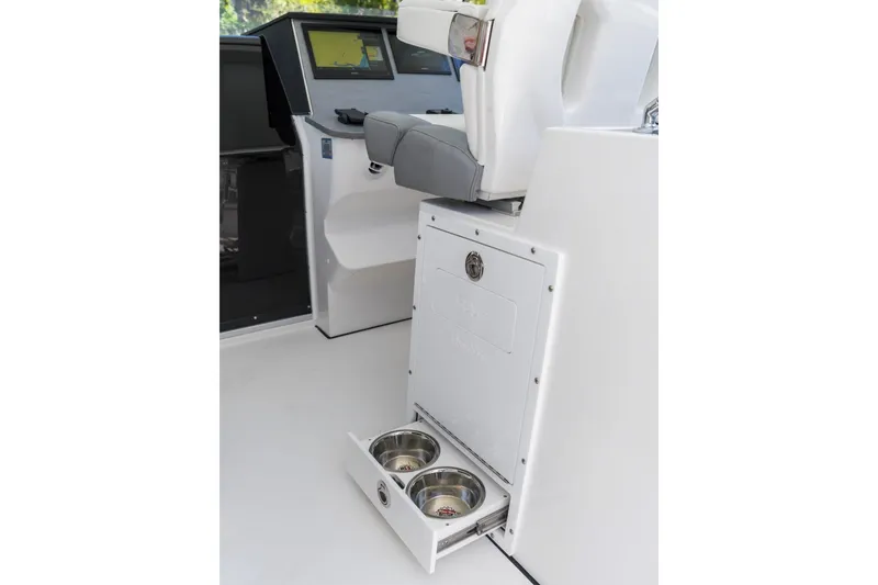Slide: The Image of 2026 Edgewater boat interior with pull-out pet bowls under the helm seat. - 8