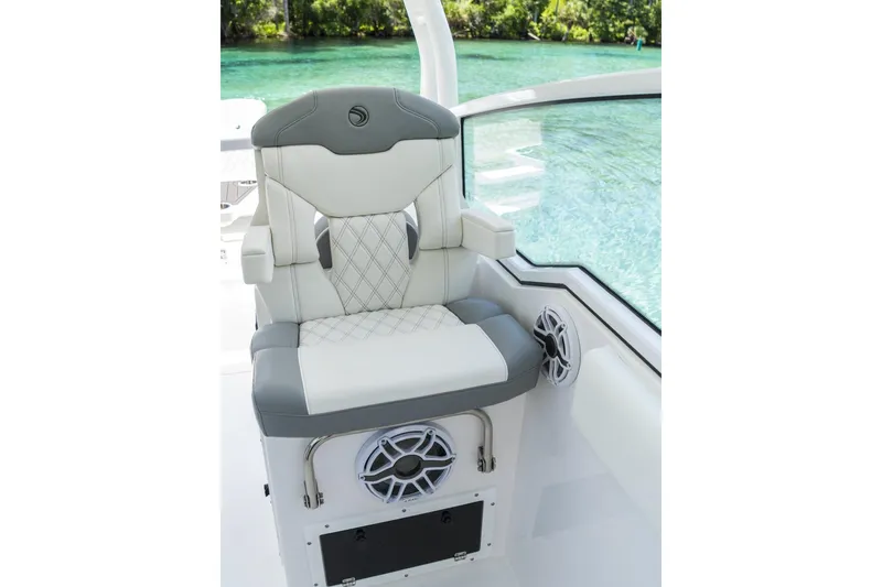 Slide: The Image of Luxurious 2026 Edgewater boat seat with speakers, overlooking clear water and lush greenery. - 9
