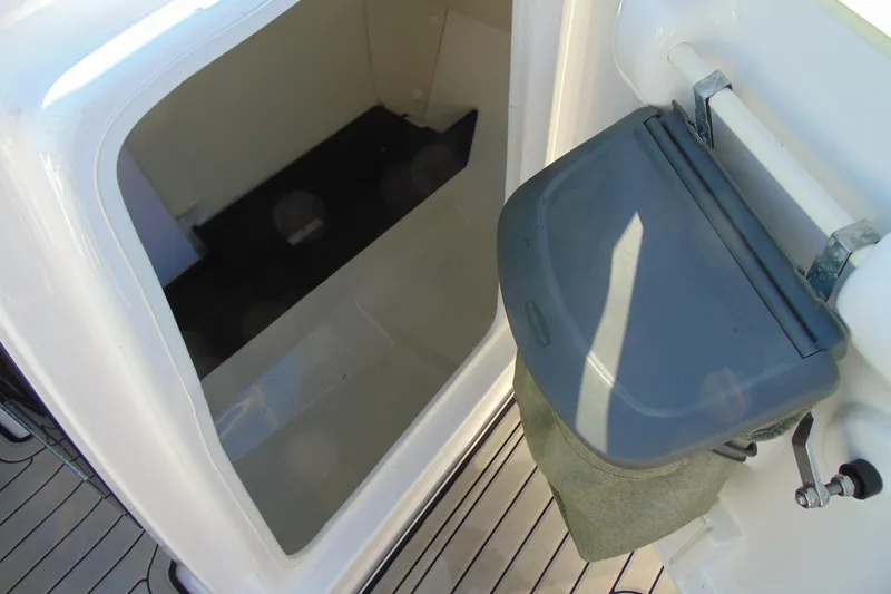 Slide: The Image of 2020 Yamaha Boats 242SE storage compartment with a foldable seat on deck. - 14