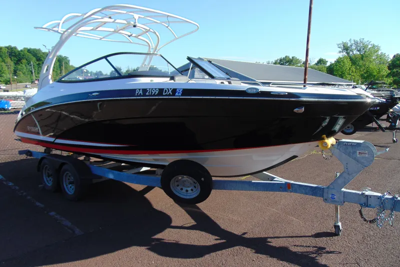 Slide: The Image of 2020 Yamaha Boats 242SE on trailer, black hull, parked outdoors. - 3