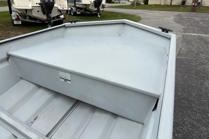 Slide: The Image of 2011 SeaArk 1448 MV boat interior with storage compartment, parked on pavement. - 13