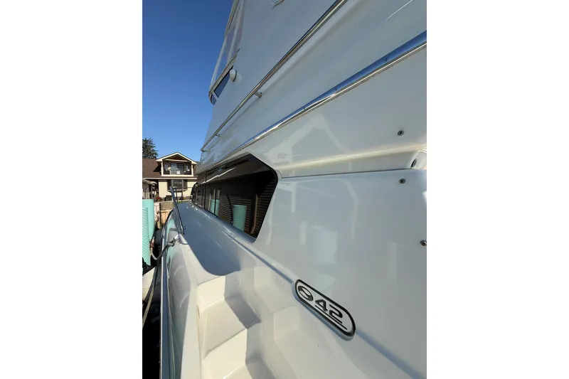 Slide: The Image of 2001 Silverton 42 Convertible yacht side view with clear blue sky background. - 10