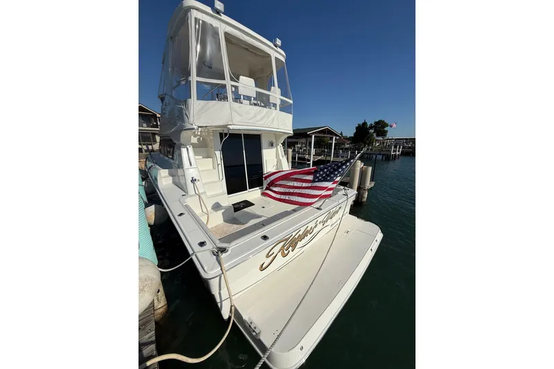 Slide: The Image of 2001 Silverton 42 Convertible yacht docked with American flag displayed. - 11