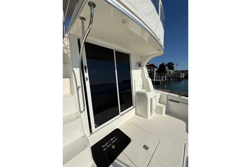 Slide: The Image of 2001 Silverton 42 Convertible yacht deck with sliding glass doors and outdoor sink. - 14