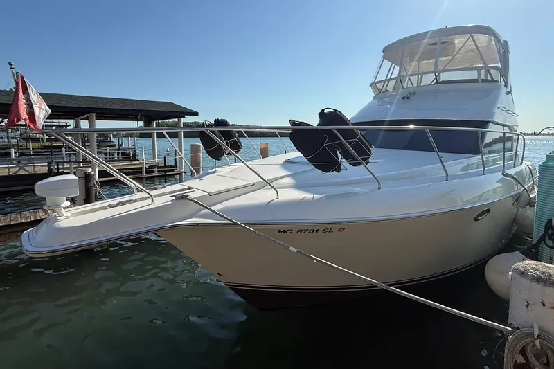 Slide: The Image of 2001 Silverton 42 Convertible yacht docked at a marina under clear blue skies. - 3