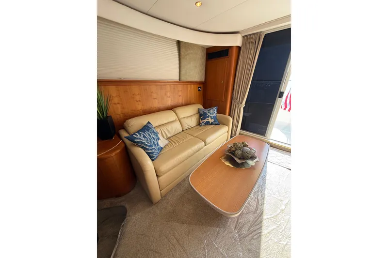 Slide: The Image of Luxurious interior of 2001 Silverton 42 Convertible yacht with beige sofa and decorative pillows. - 32